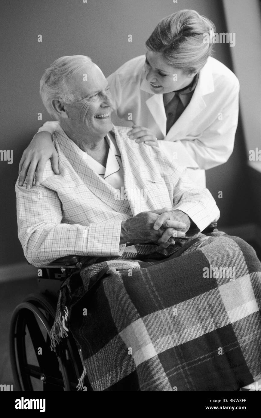 Doctor talking to senior man in wheelchair Stock Photo