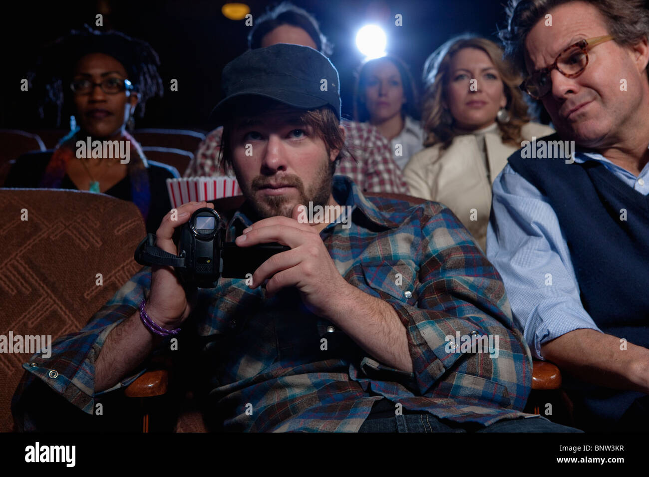 Man using video recorder in movie theatre Stock Photo Alamy