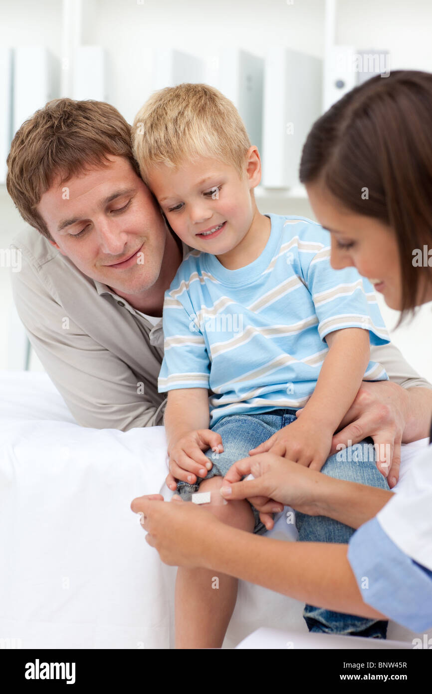 Doctor applying a plaster on a patient's knee Stock Photo