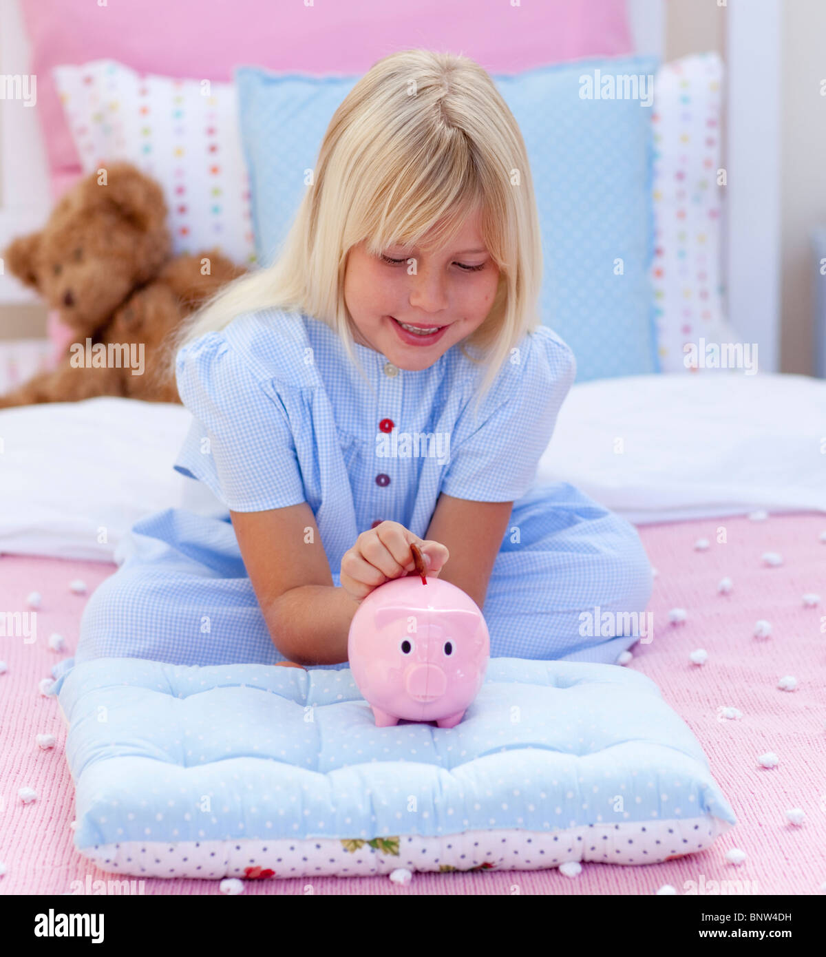 Little girl saving money in a piggy bank Stock Photo - Alamy