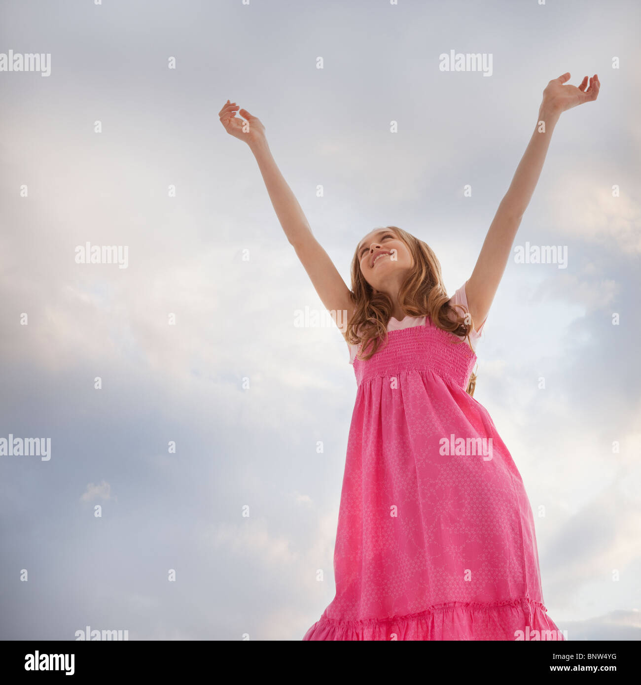 Teenage girl raising her arms in the air Stock Photo
