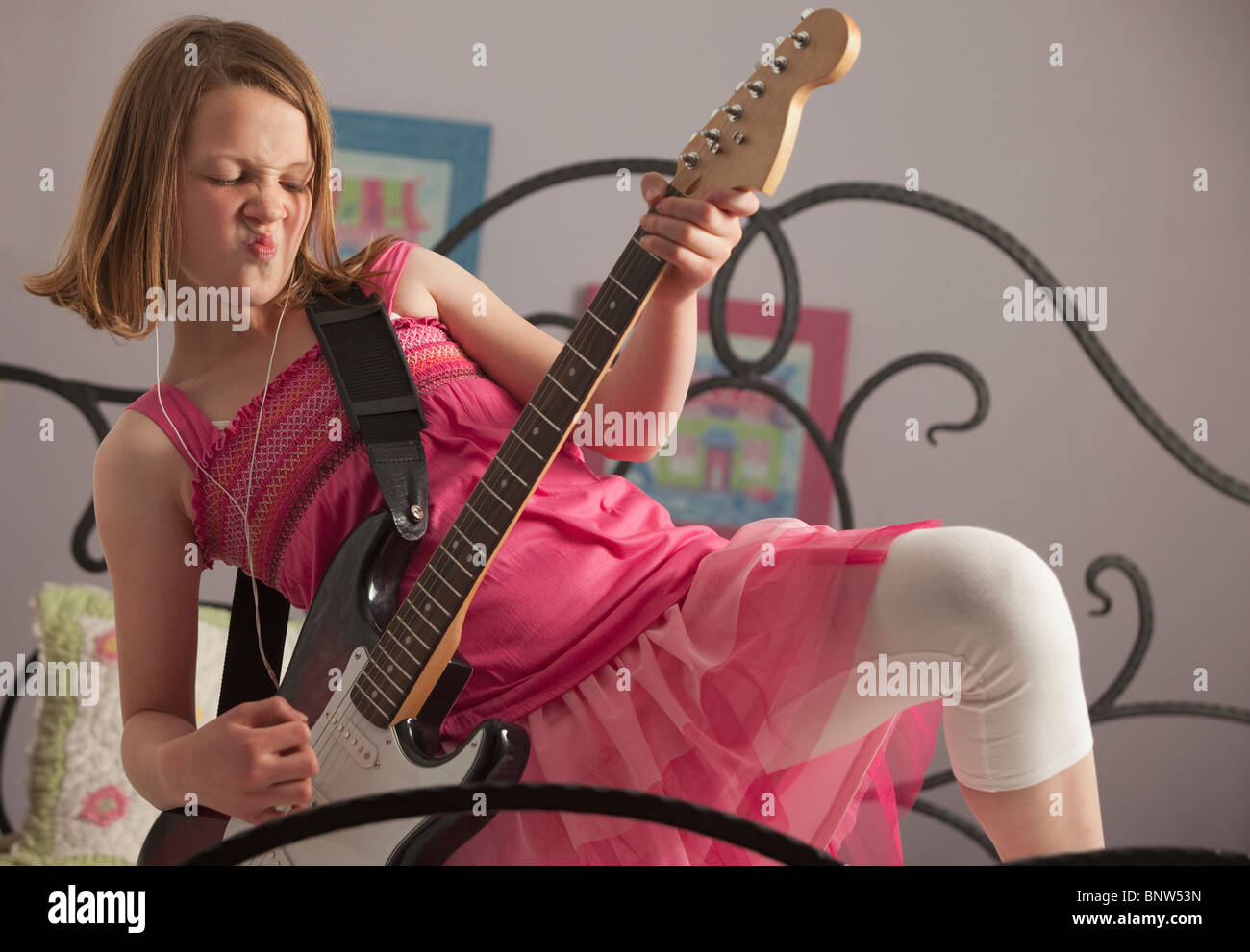 Young girls playing guitar on her bed Stock Photo