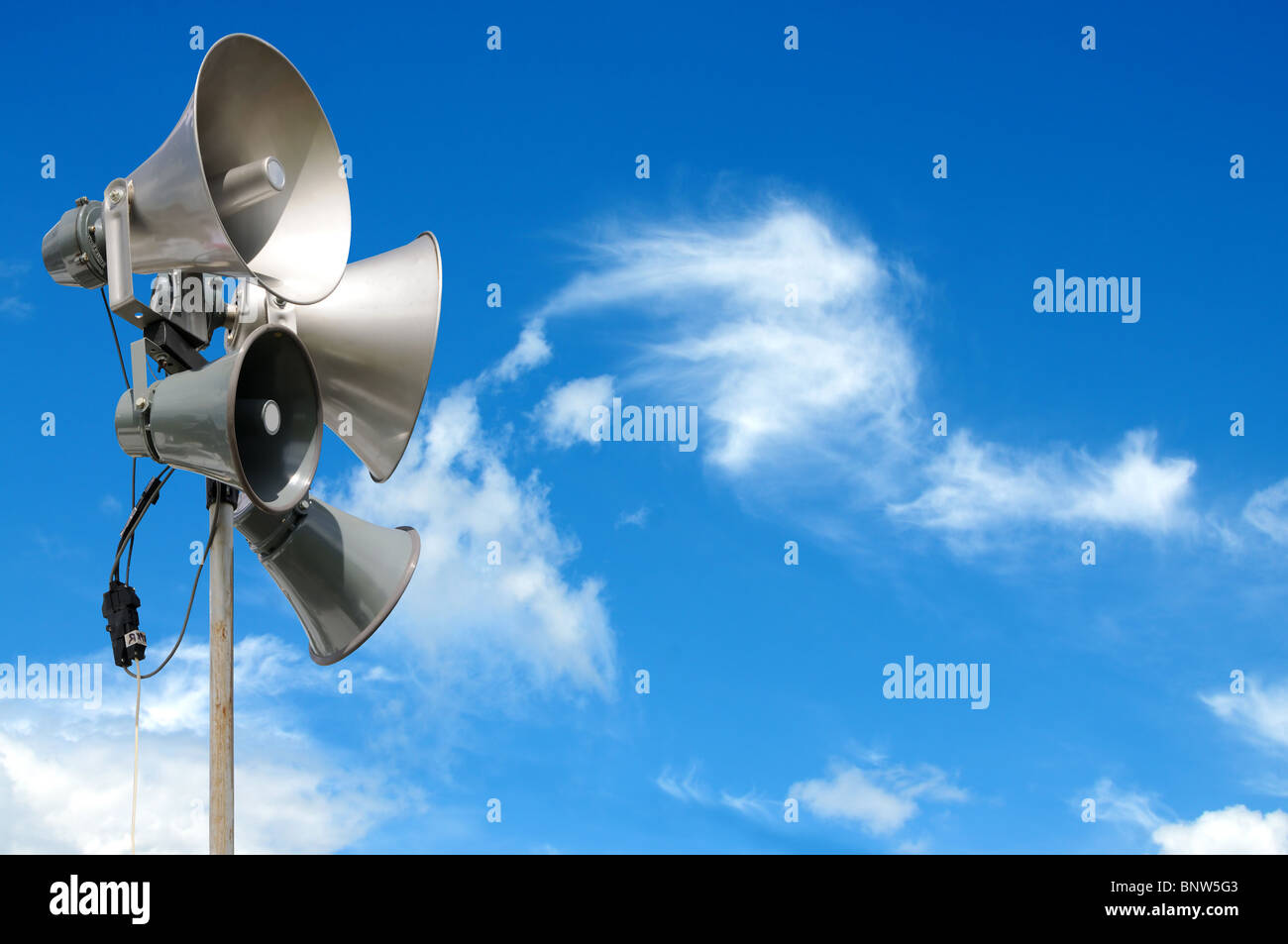 PA / Public Address system speakers, against a bright blue sky, with space for your text / editorial overlay Stock Photo