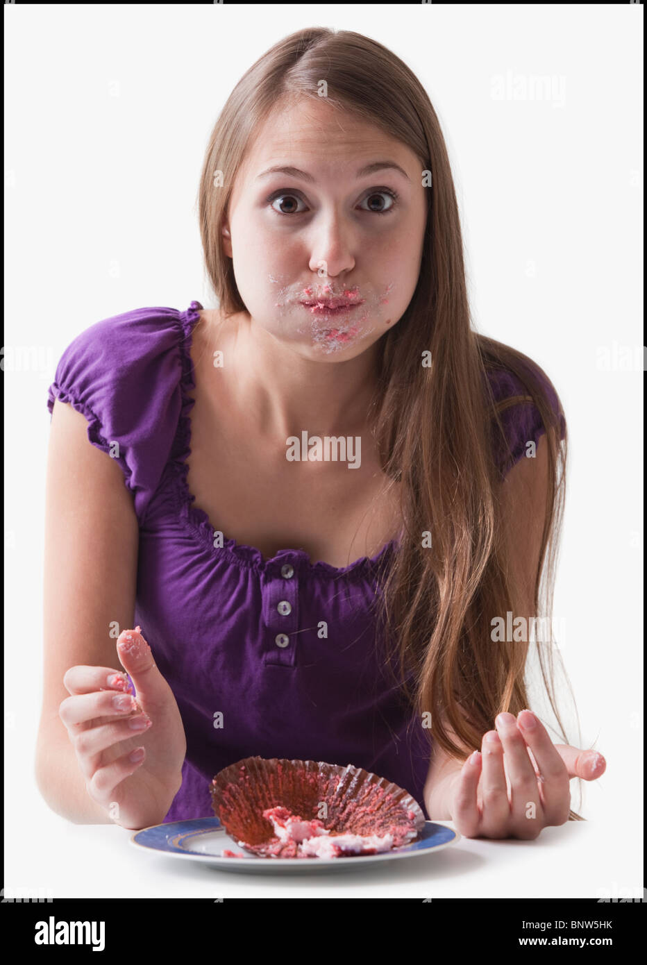 Woman with a cupcake stuffed in her mouth Stock Photo