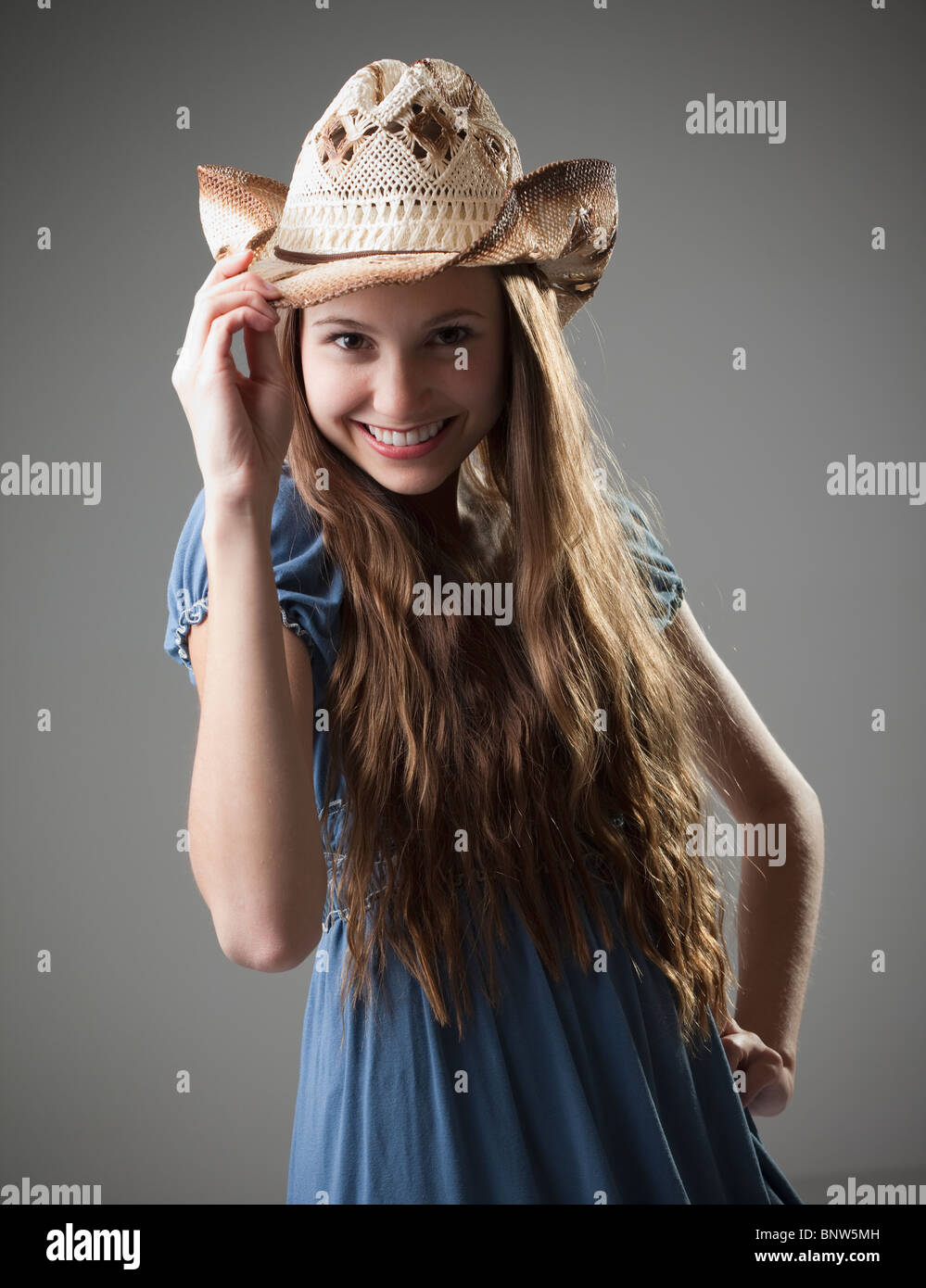 Beautiful long haired cowgirl tipping her hat Stock Photo