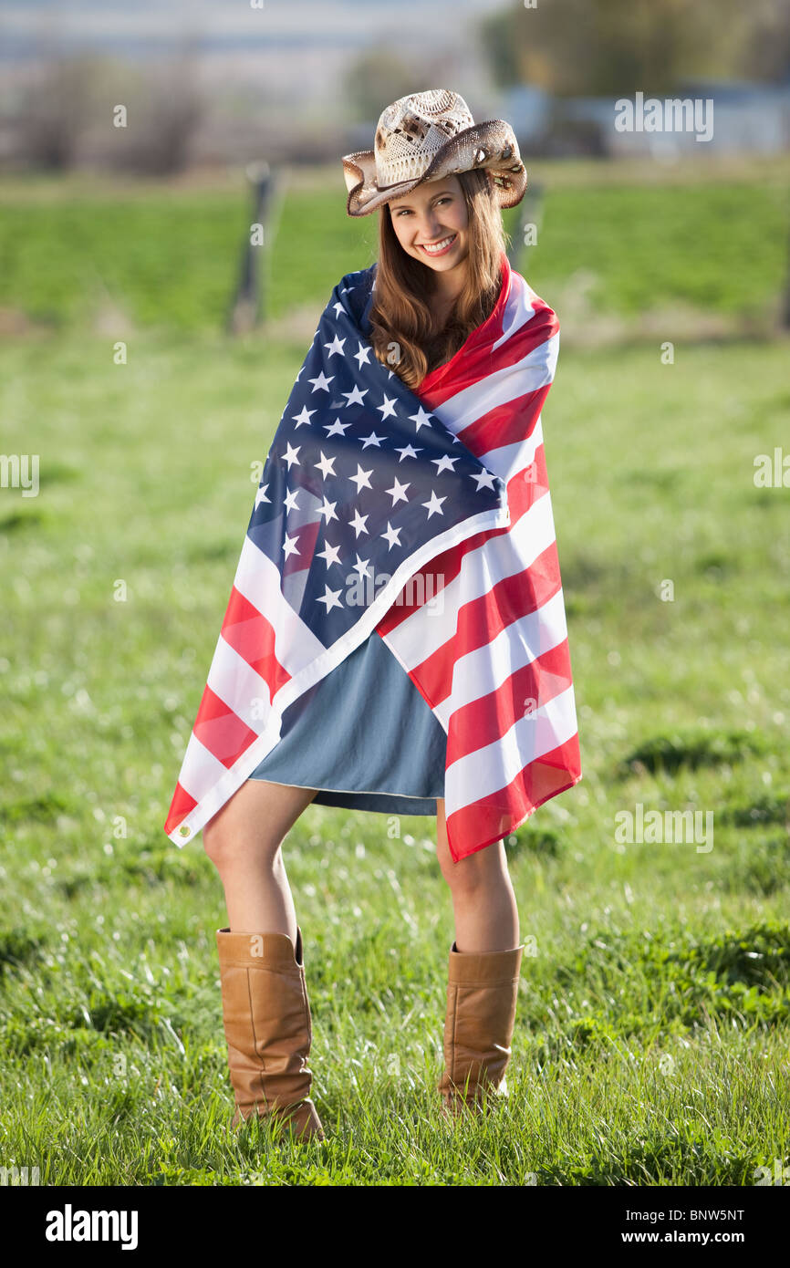 Beautiful cowgirl wrapped in American flag Stock Photo