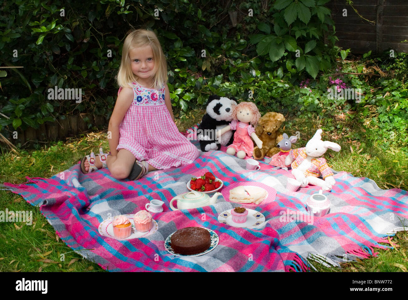 A young girl enjoying a picnic tea party with her toys Stock Photo - Alamy