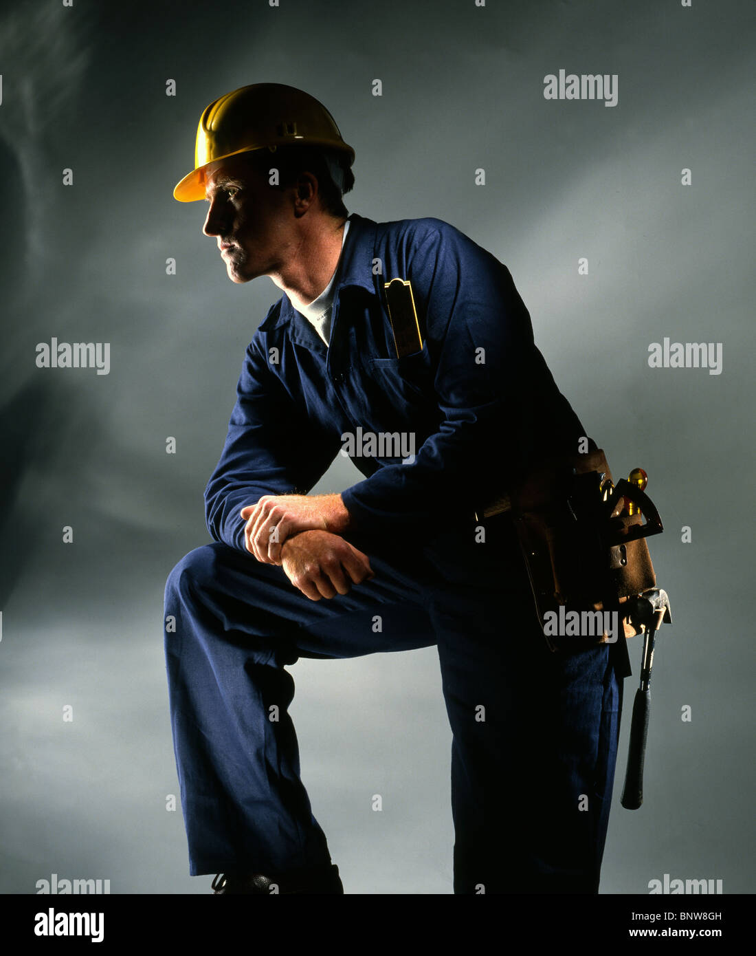 Builder / Handyman in traditional blue boiler suit in yellow safety ...