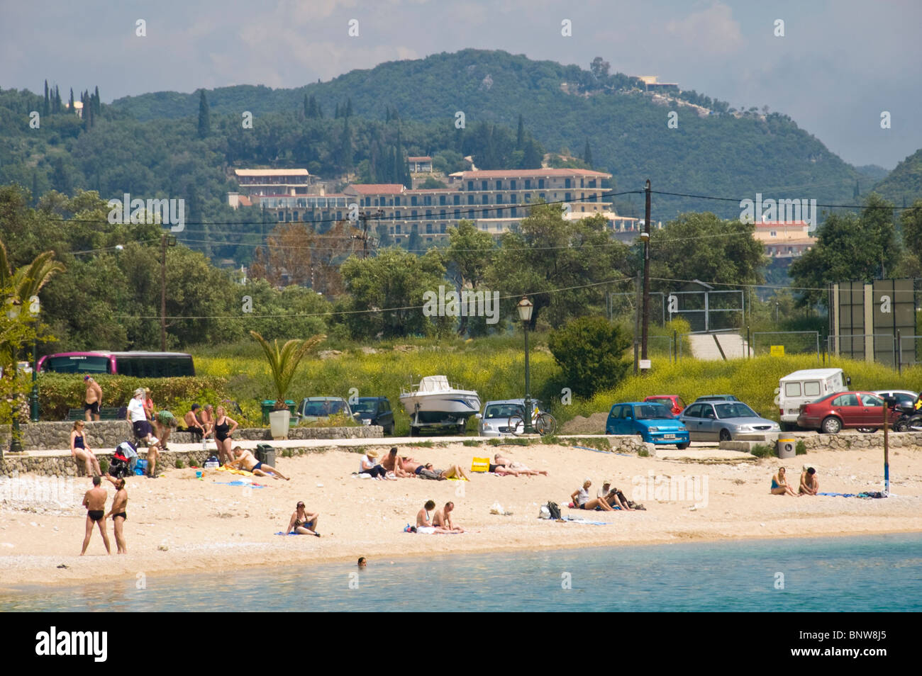 Corfu beach. Tourists relaxing on sandy beach at Paleokastritsa on the Greek island of Corfu Greece GR Stock Photo