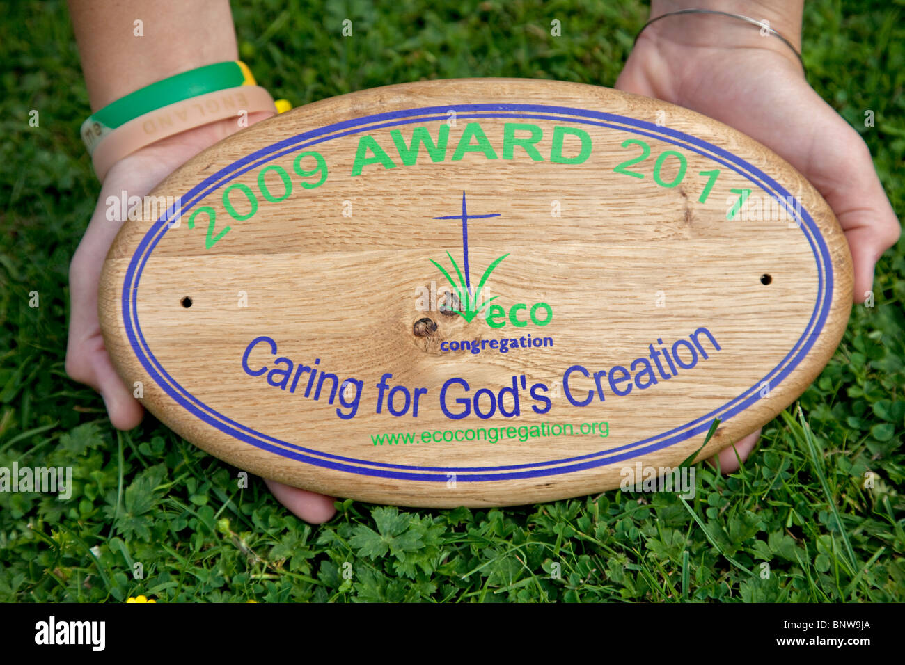 Hands holding Eco Congregation plaque 3rd award UK Stock Photo