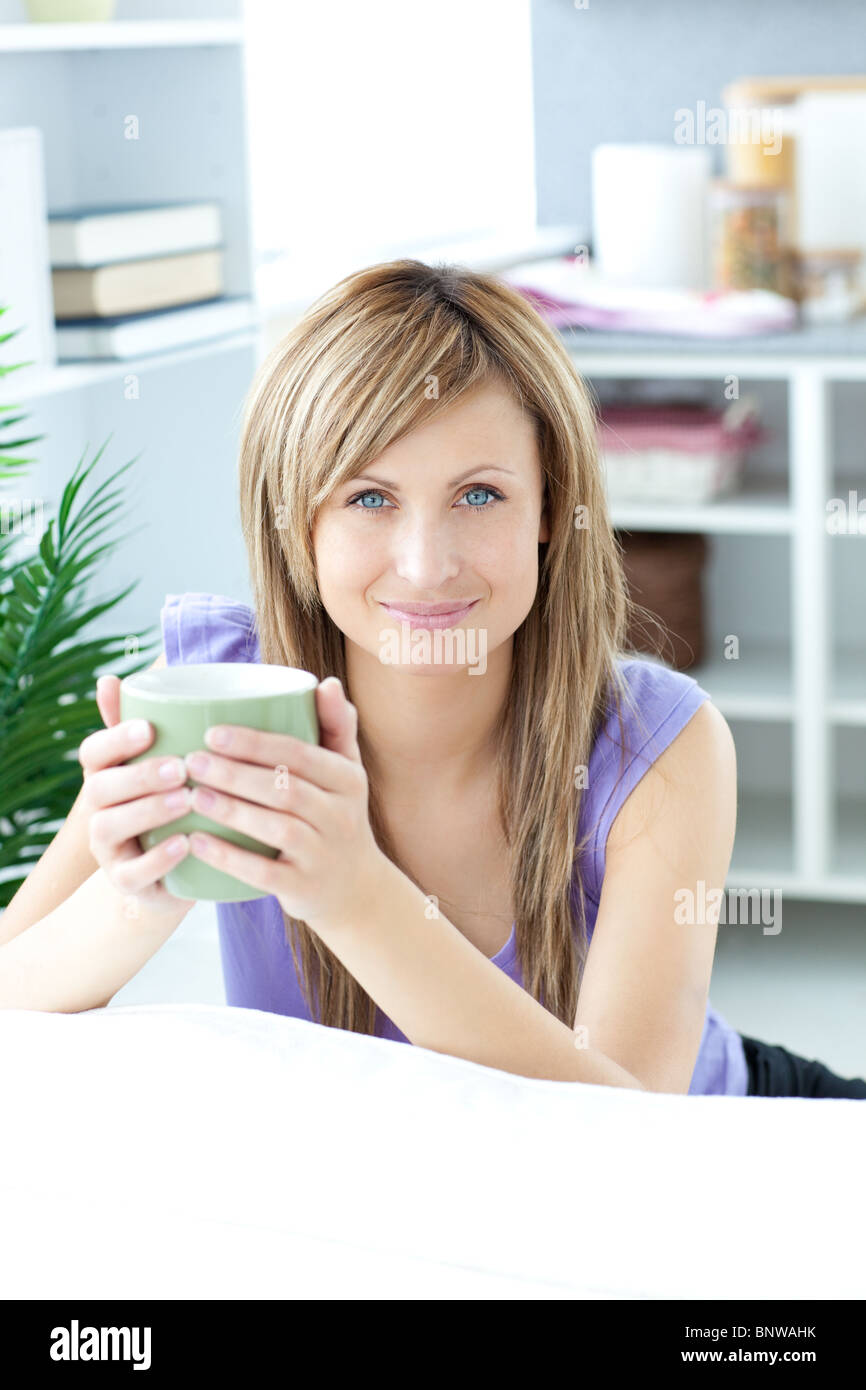 Young woman holding a cup of coffee in the kitchen Stock Photo