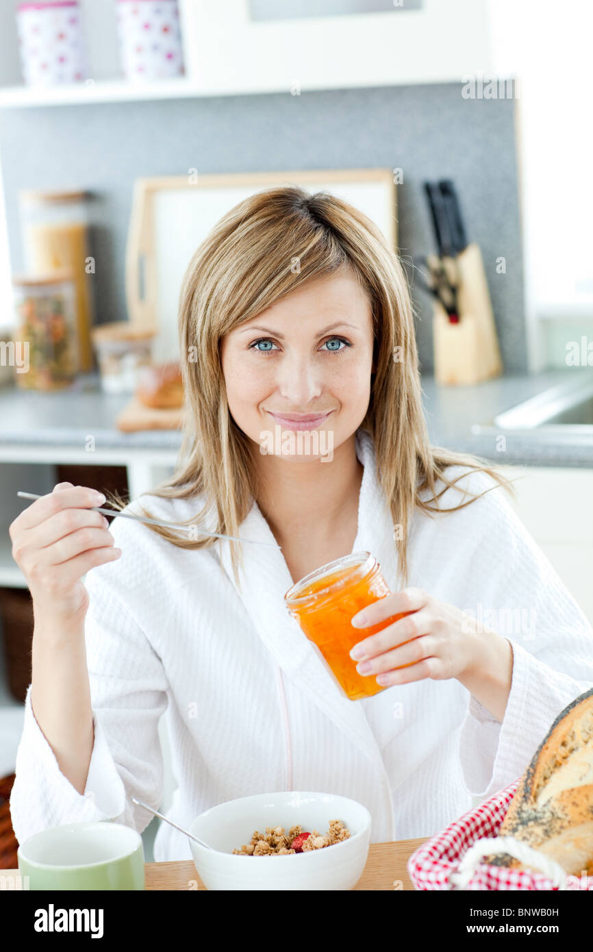 Delighted woman having breakfast in the kitchen Stock Photo
