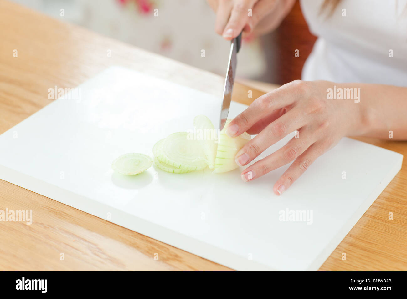 Delighted woman preparing oinion in the kitchen Stock Photo