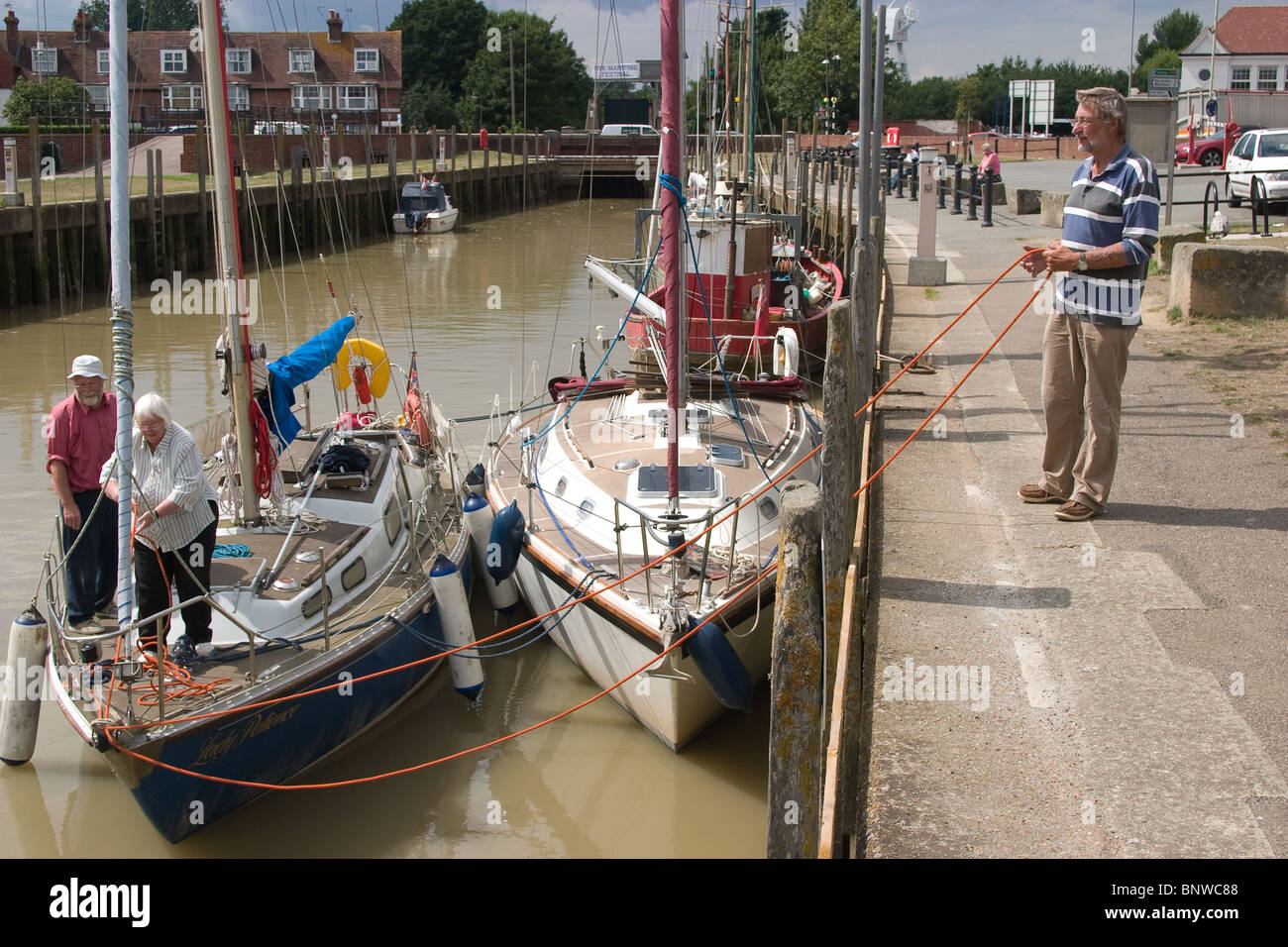 tied double berthed sailing boat sailors talking Stock Photo - Alamy