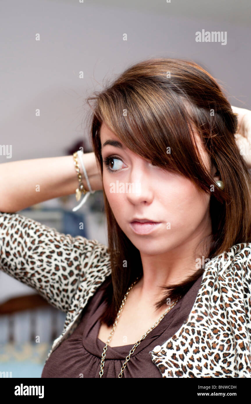 A pretty 16 year old girl fixes her hair before going shopping at the mall. Stock Photo