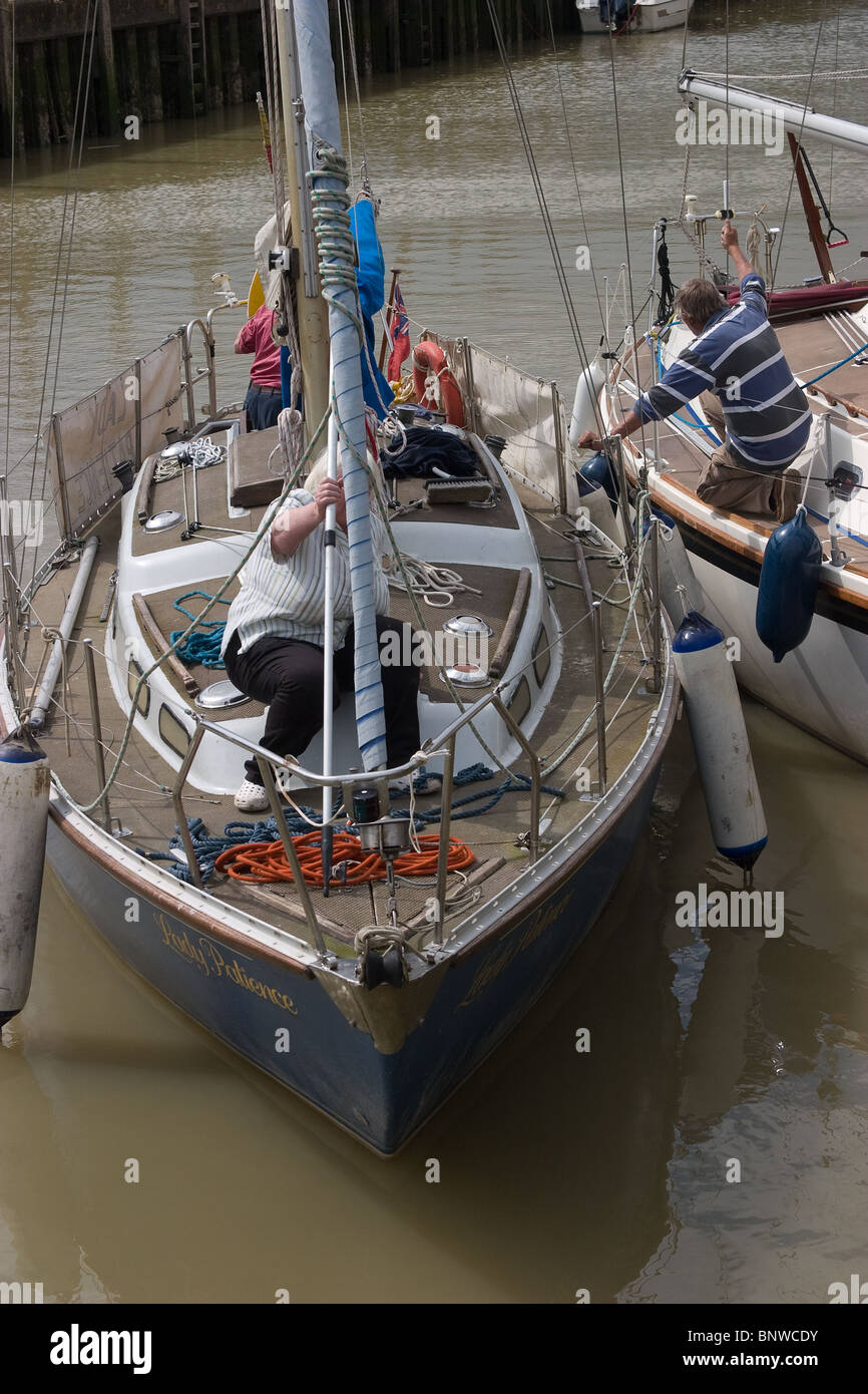 tied double berthed sailing boat sailors helping Stock Photo