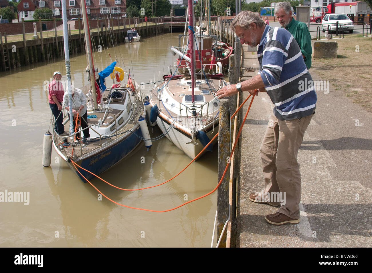 tied double berthed sailing boat sailors talking Stock Photo