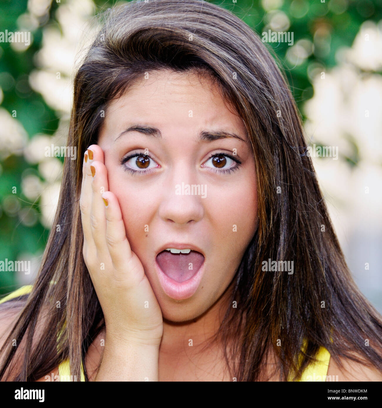 Closeup of a teenage girl's face showing shock and unhappy surprise. Brunette, Caucasian, brown eyes. Outdoors. USA. Stock Photo