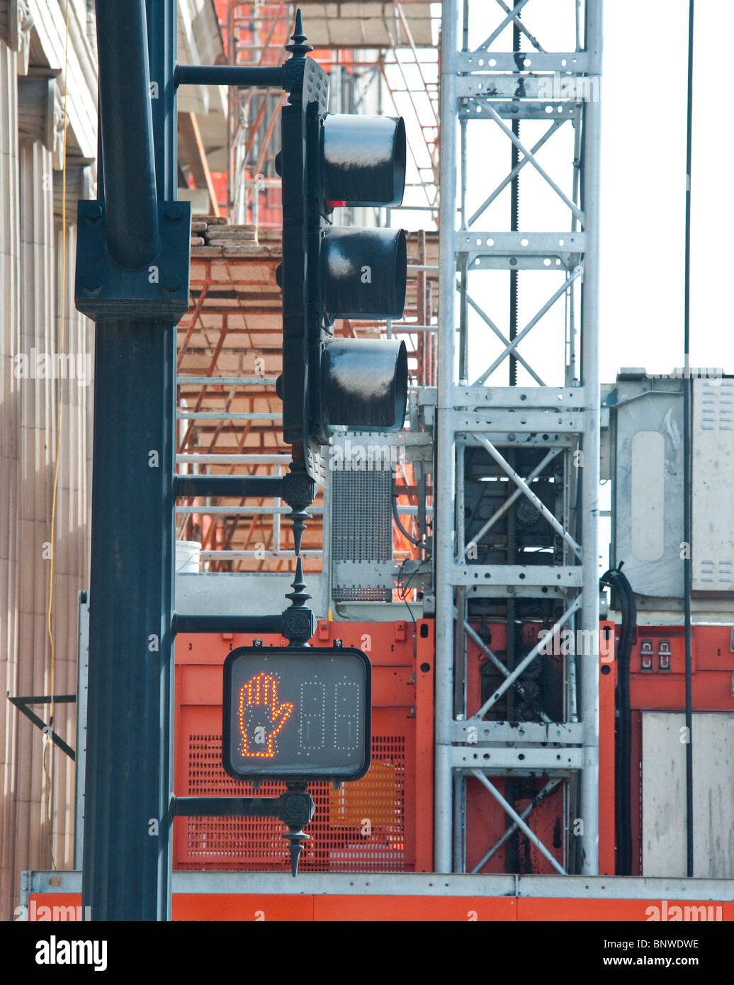 Crosswalk signal with construction scaffolding in background Stock Photo
