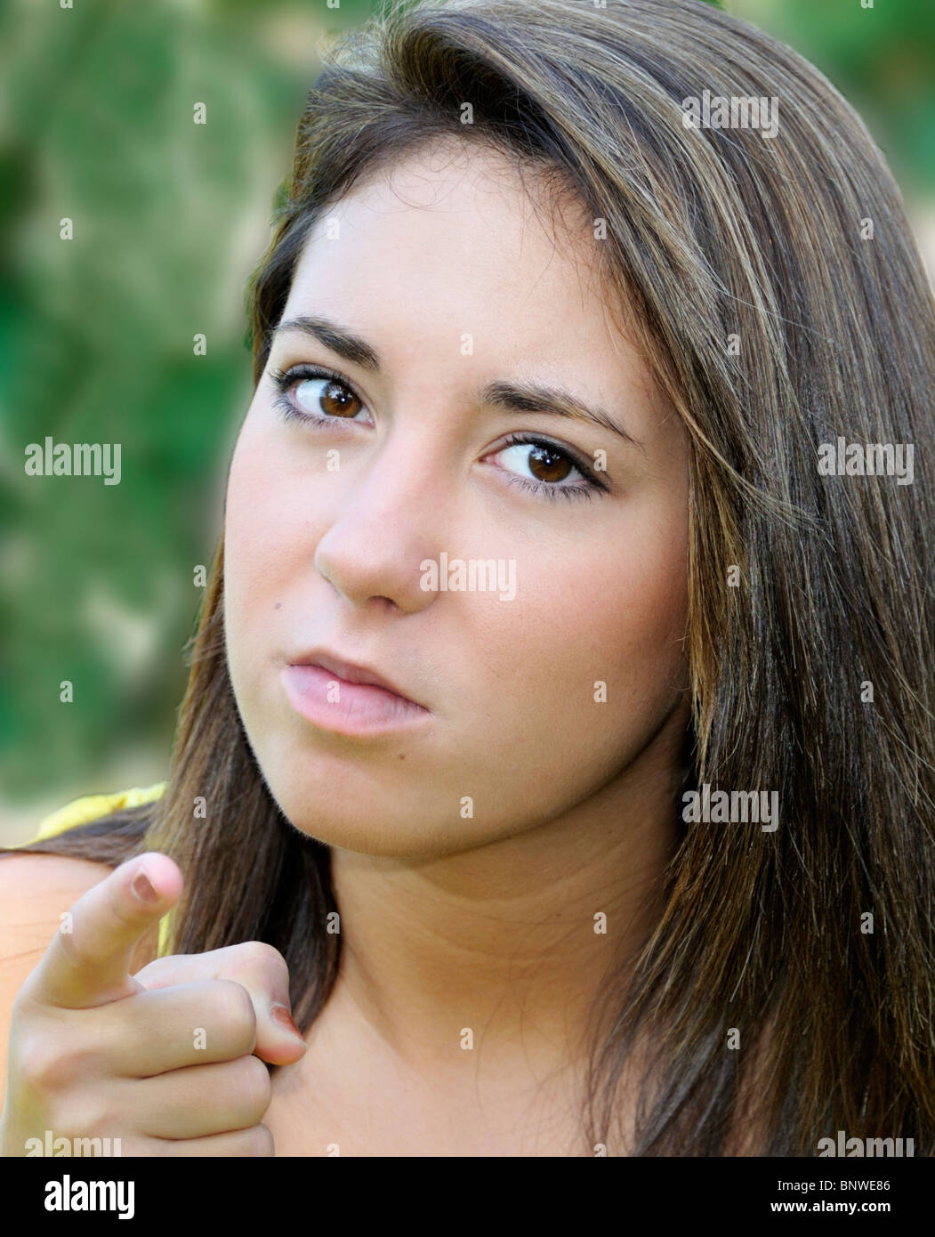 A pretty, Caucasian teenage girl points her finger with an angry expression on her face. Stock Photo