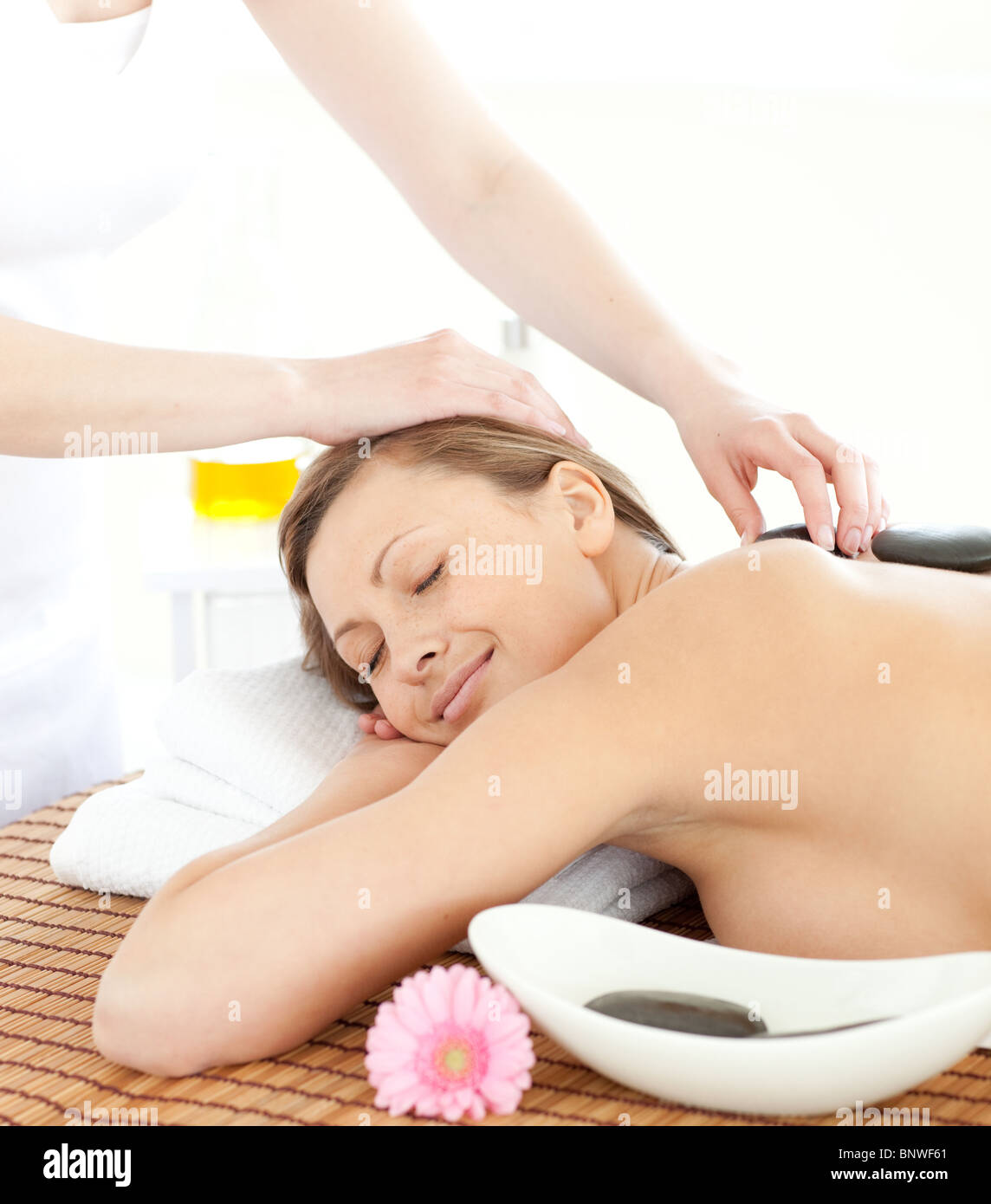 Portrait of a cheerful woman having a massage with stones Stock Photo