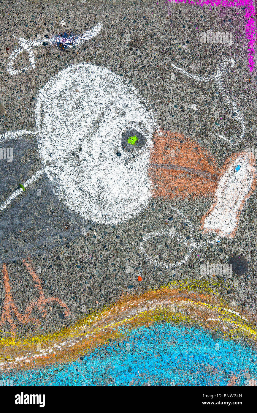 abstract eagle with white head & orange beak & talons holds fish from blue water in drawing by young boy at Chalk Art Festival Stock Photo