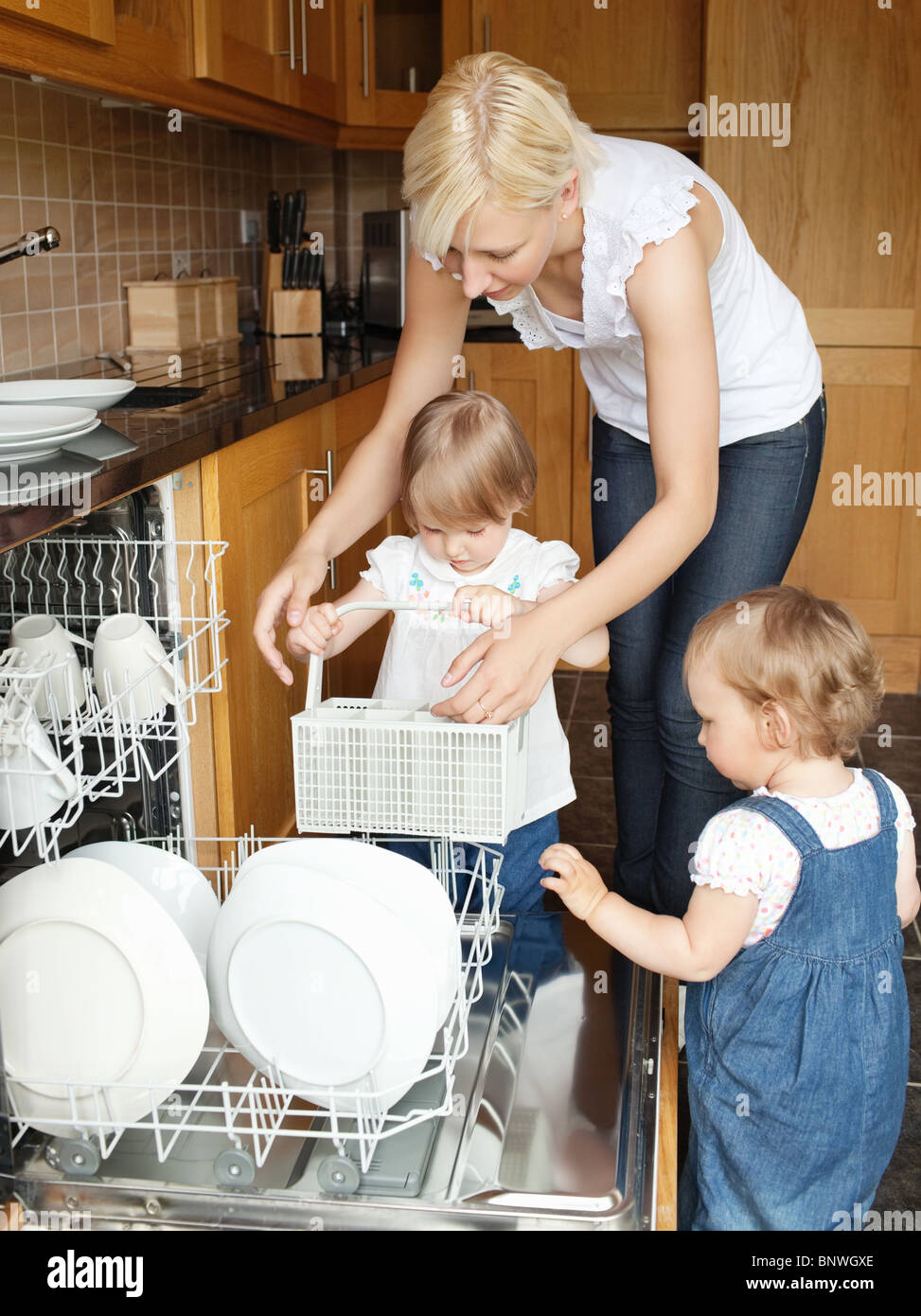 Family put dishes in the dishwasher Stock Photo Alamy