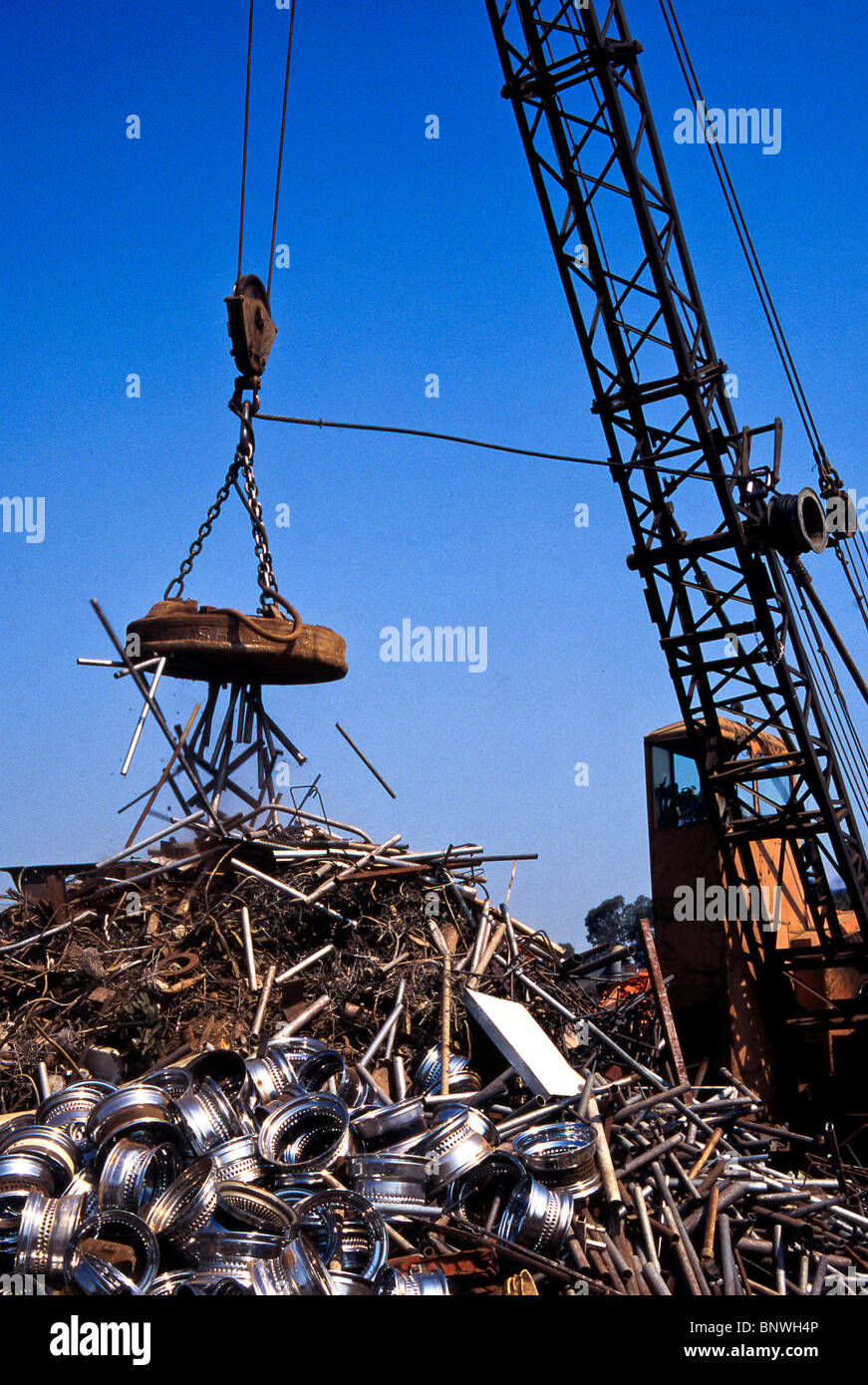 A giant cranemounted is used to move a pile of iron and