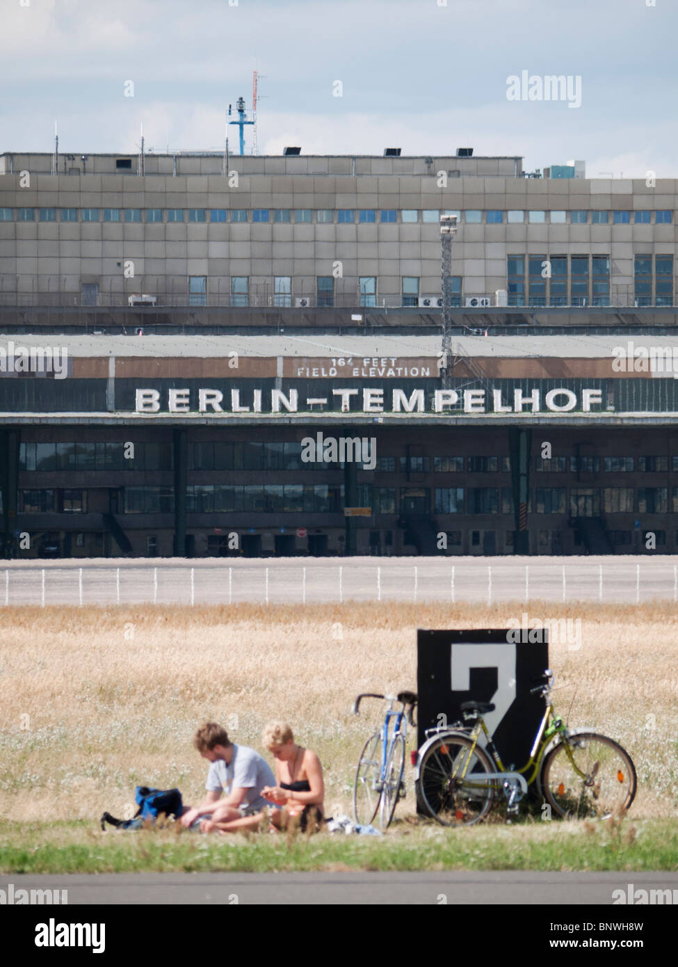 People having picnic next to runway at new city public Tempelhofer Park on site of  former Tempelhof Airport in Berlin Germany Stock Photo