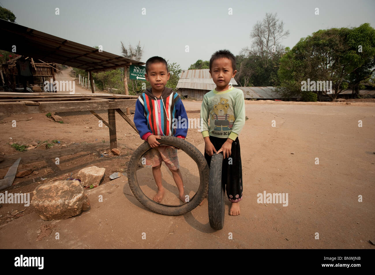Two boys playing with tires in the Mae Rim District, Chiang Mai Province, Thailand, Asia Stock Photo