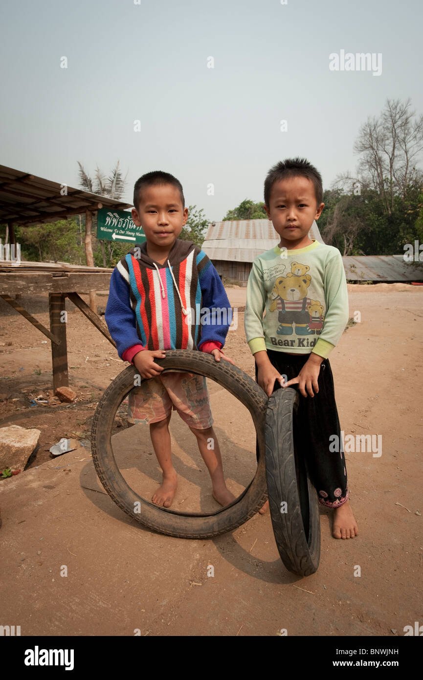 Two boys playing with tires in the Mae Rim District, Chiang Mai Province, Thailand, Asia Stock Photo