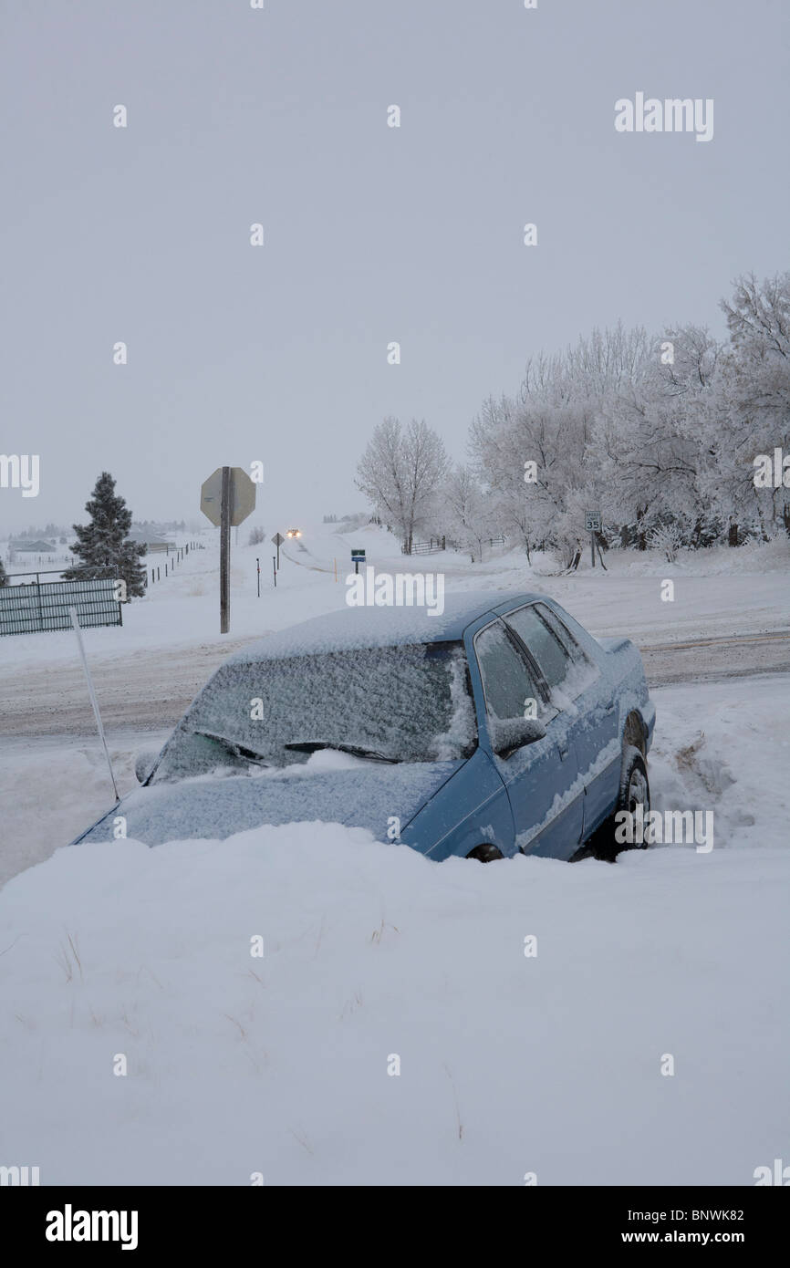 Winter single car traffic accident. Snow falls on car stuck in ditch