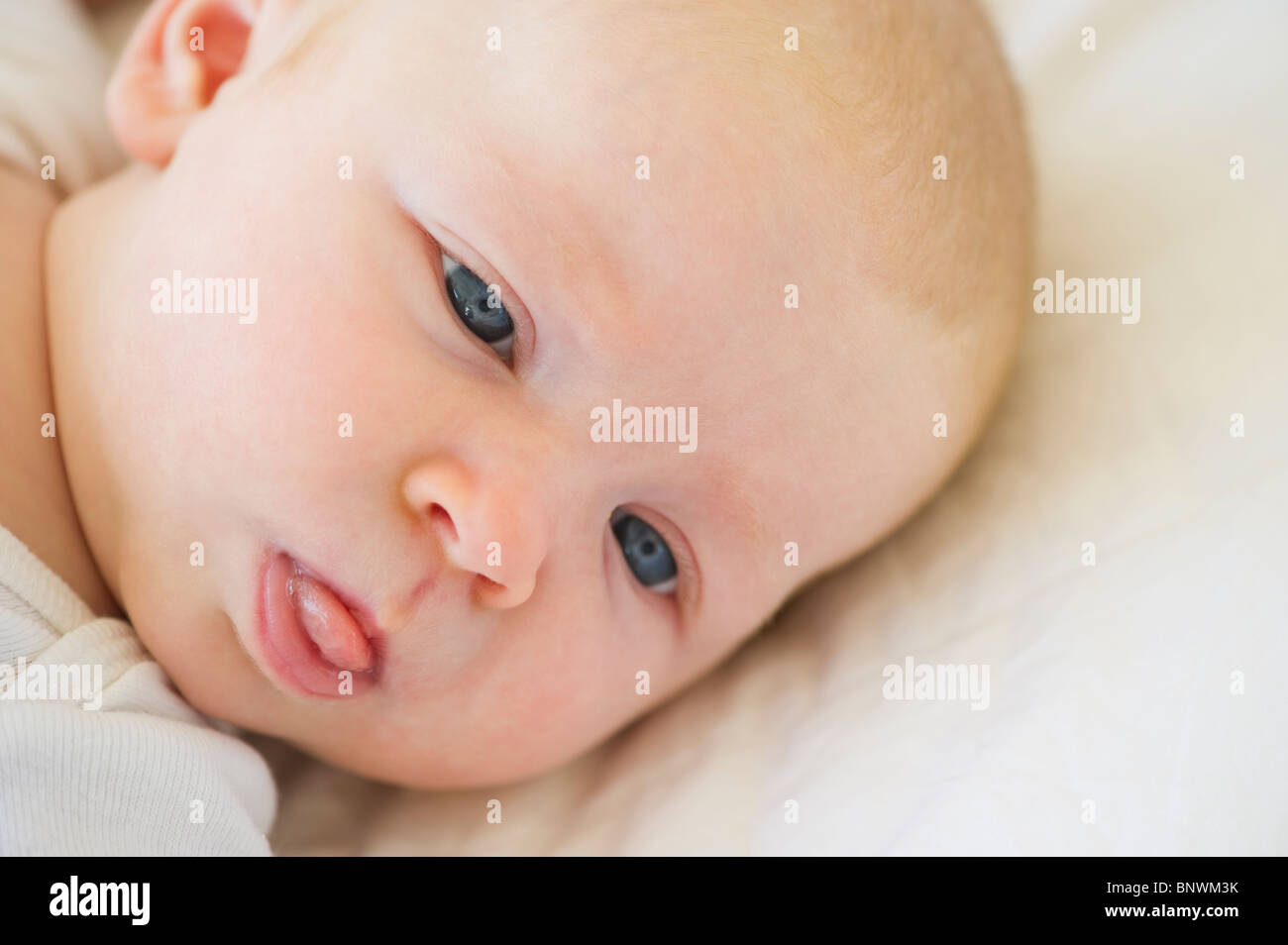 Infant sticking his tongue out Stock Photo Alamy