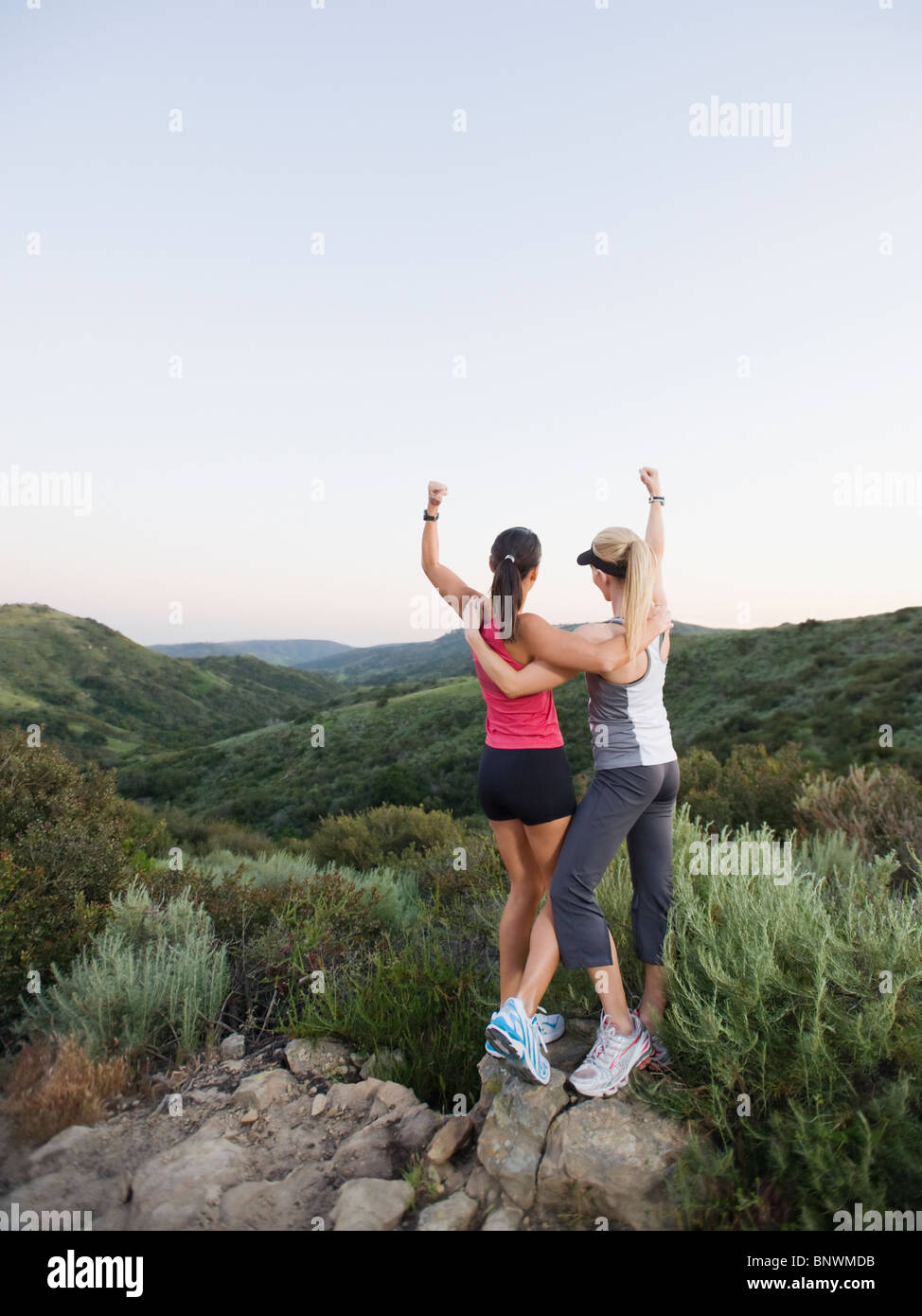Two women raising their arms in victory Stock Photo - Alamy
