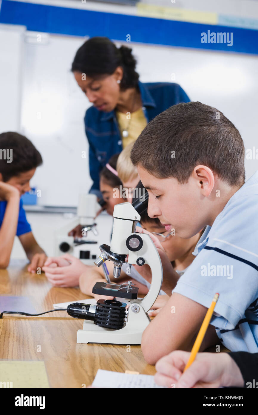 Elementary students using microscopes Stock Photo