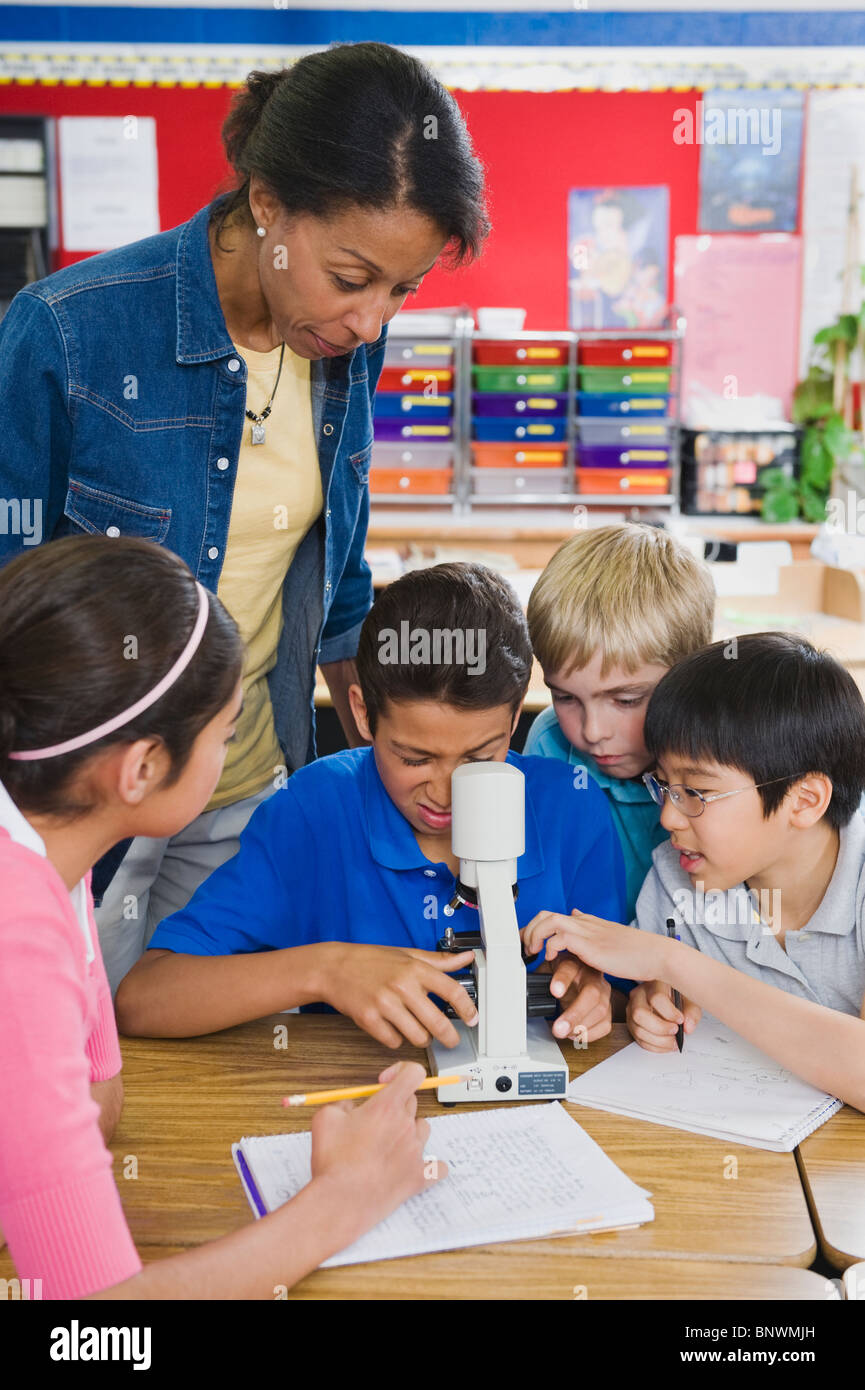 Teacher and elementary students looking at microscope Stock Photo Alamy