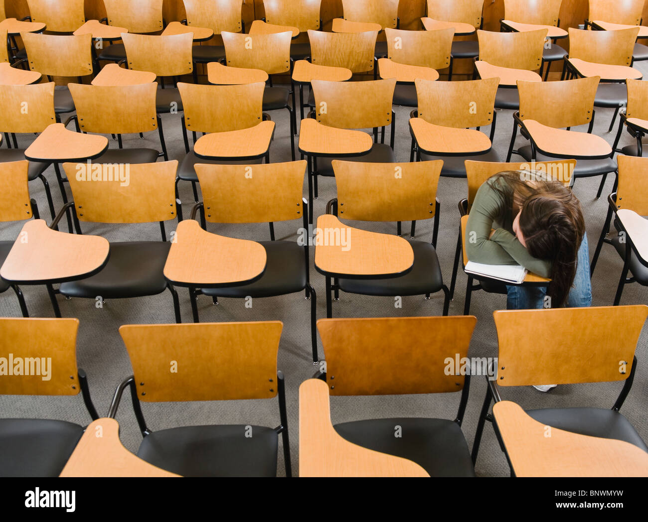 College student sleeping in empty lecture hall Stock Photo