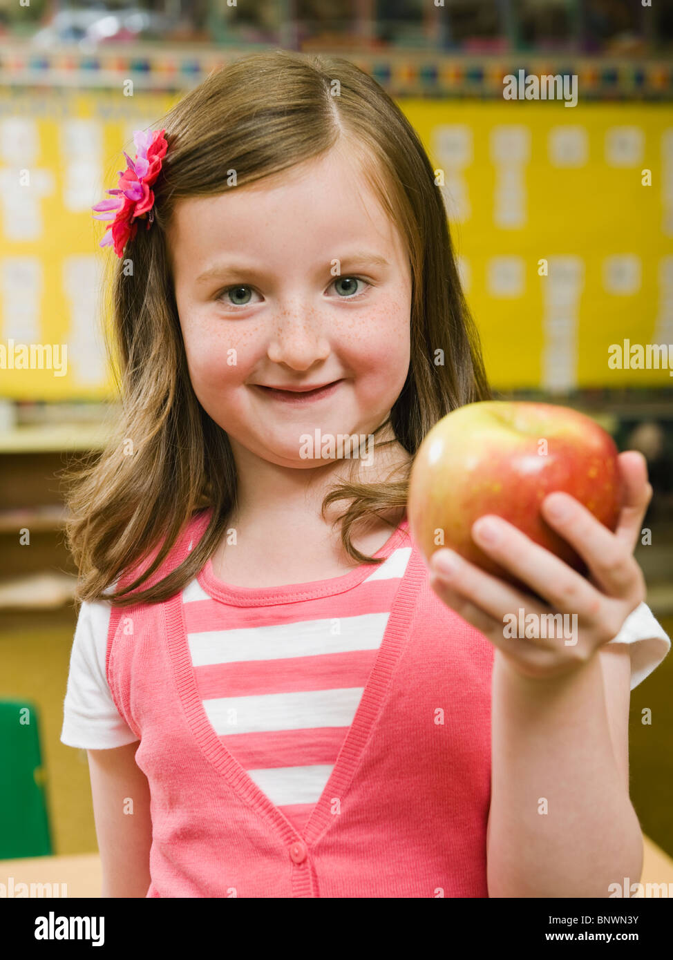 Kindergarten student holding an apple in classroom Stock Photo - Alamy