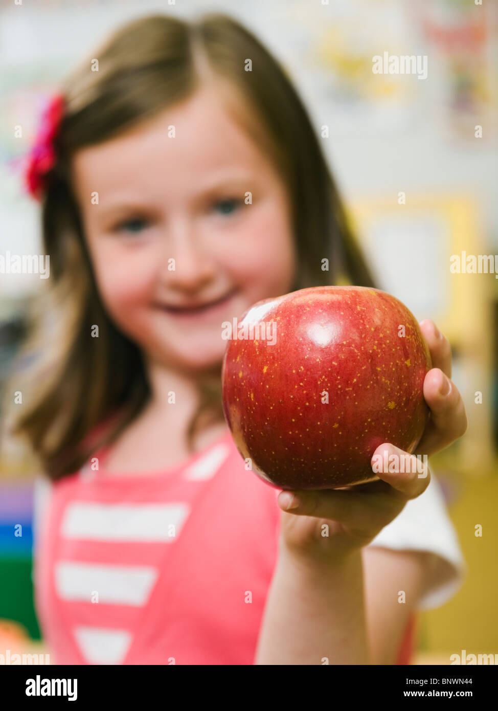 Kindergarten student holding an apple in classroom Stock Photo - Alamy