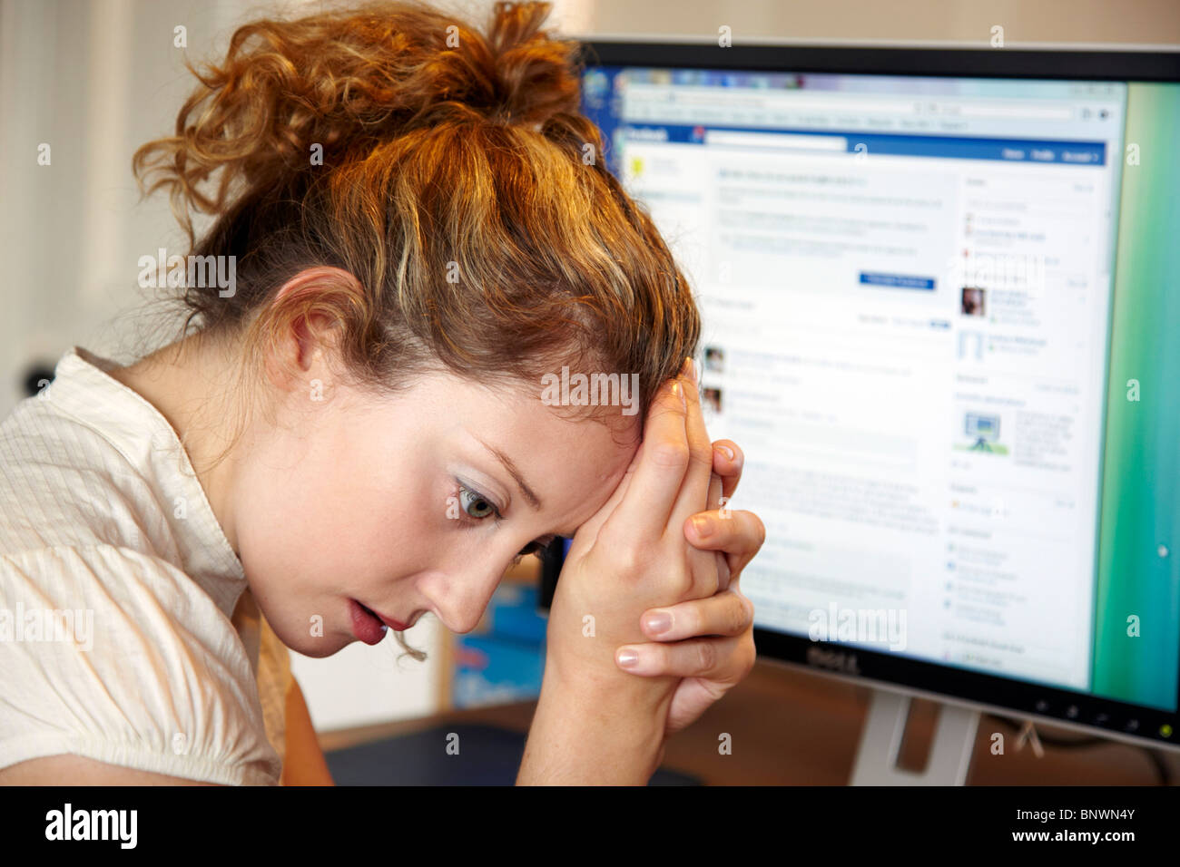 Girl looking upset at online chat line Stock Photo