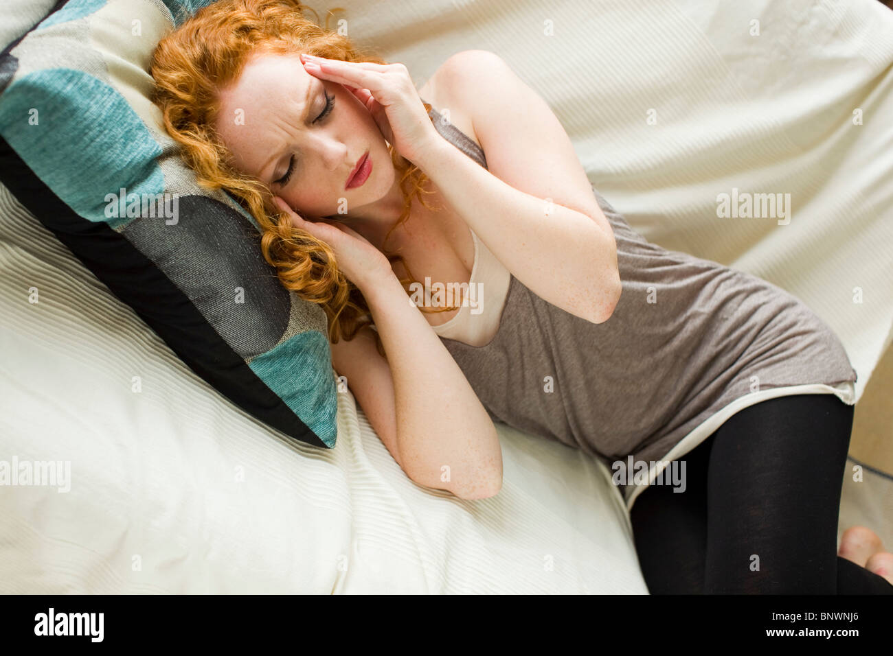 Woman lying down with headache Stock Photo