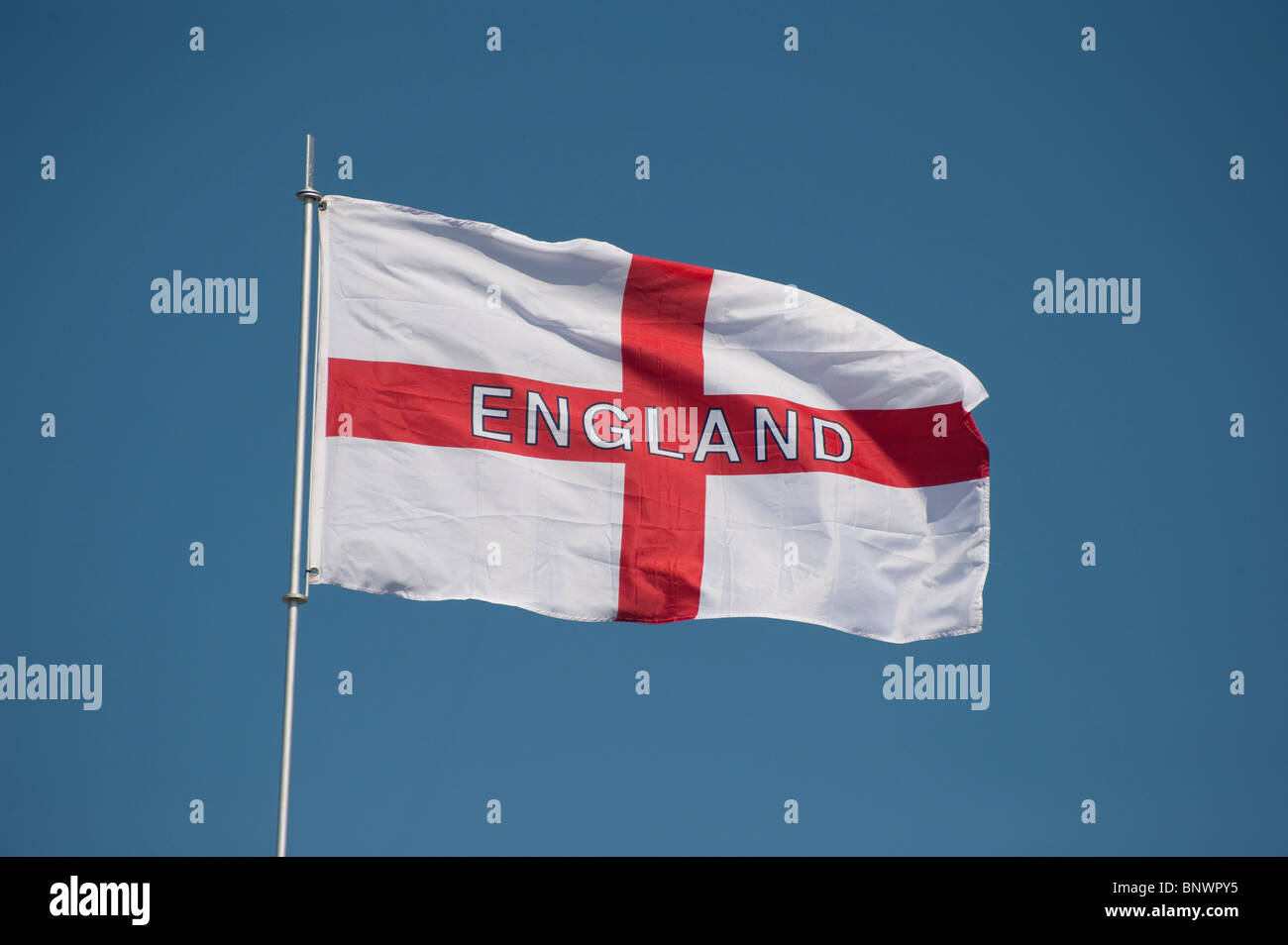 England flag flying in a bright blue sky. Stock Photo