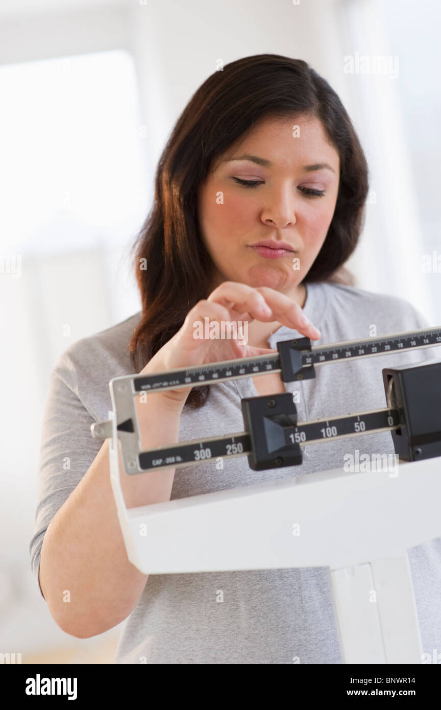 Disappointed woman standing on scale Stock Photo