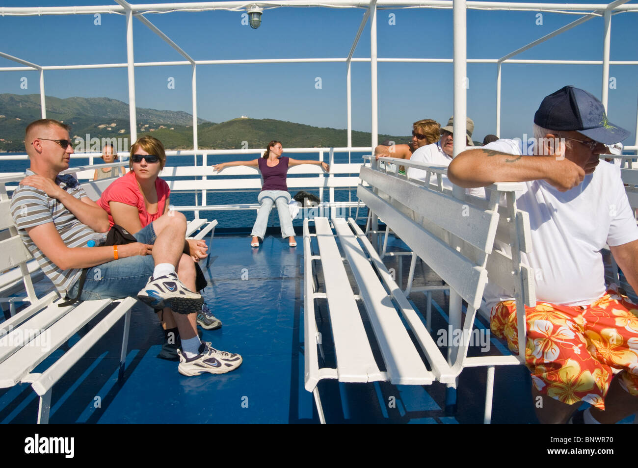 Tourists relax on deck of ferry off the Greek island of Corfu Greece GR Stock Photo