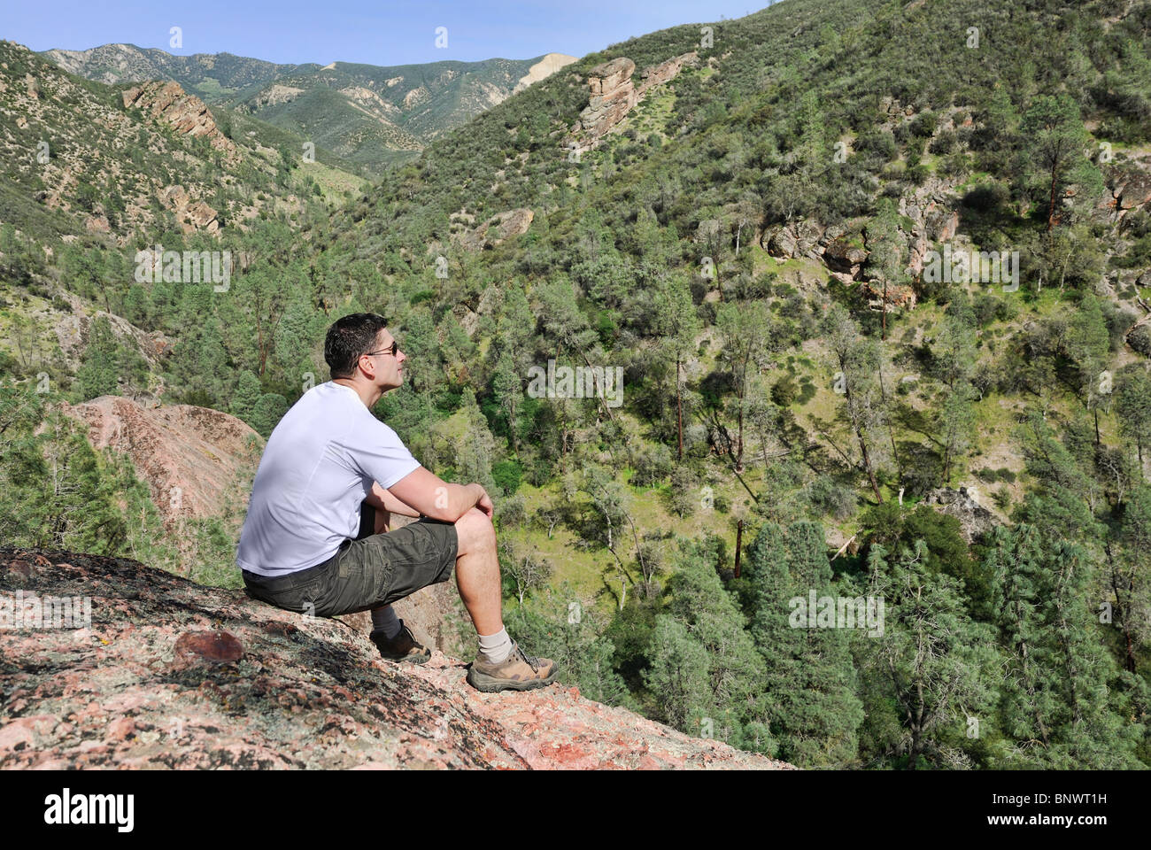 Person sitting on rock hi-res stock photography and images - Alamy