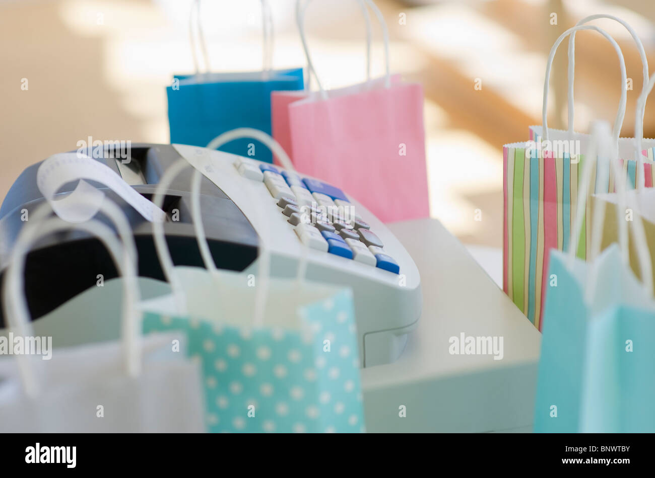 Cash register surrounded by colorful shopping bags Stock Photo