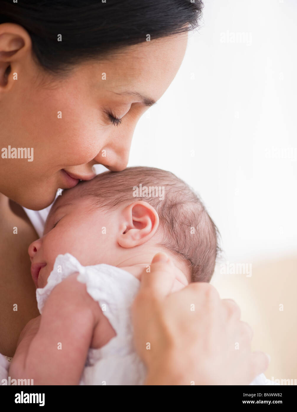 Mother kissing her baby's head Stock Photo