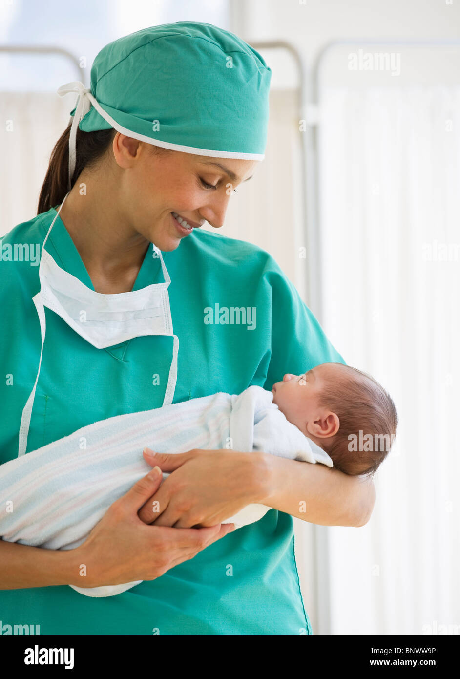 Nurse holding swaddled baby Stock Photo Alamy