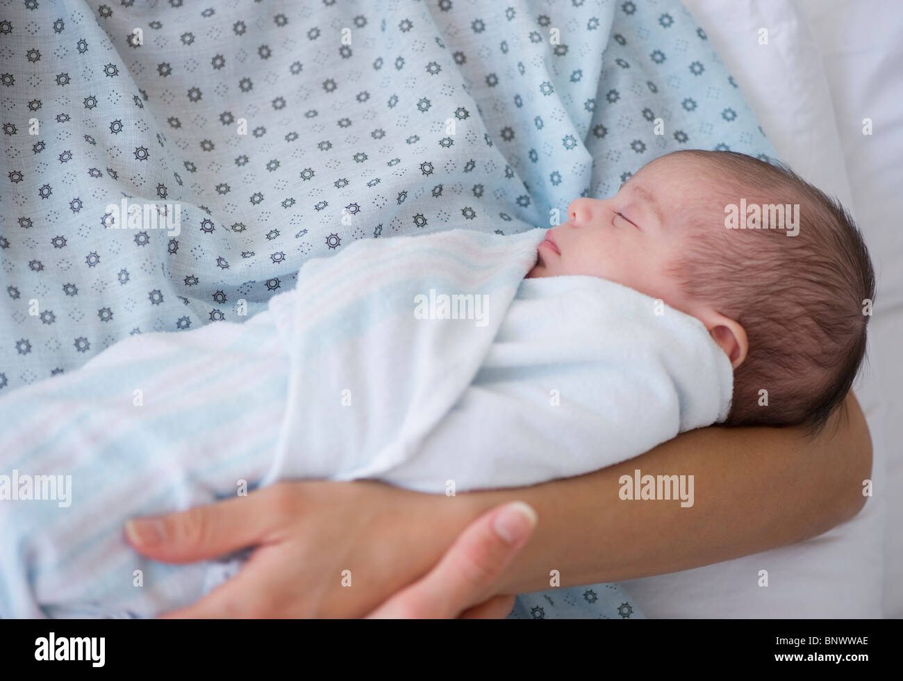 Newborn baby swaddles in mother's arms Stock Photo Alamy