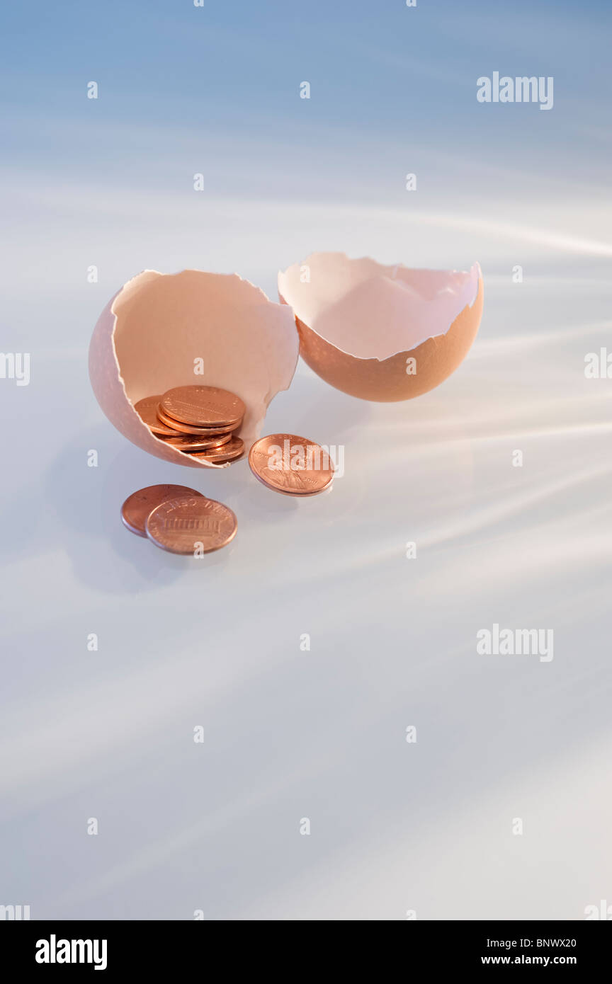 Pennies in a cracked egg shell Stock Photo